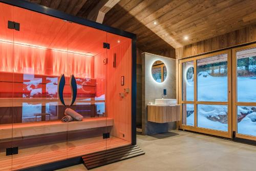 a bathroom with a large glass cabinet with surfboards on it at Luxury Chalet with Private Spa & Wellness Area in Megève
