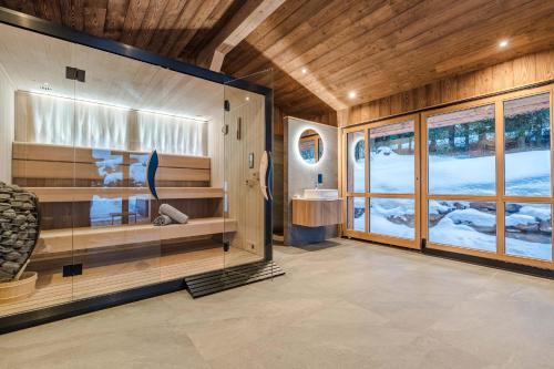 a room with a sauna with wooden walls and windows at Luxury Chalet with Private Spa & Wellness Area in Megève