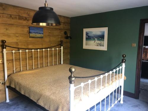 a bedroom with a bed and a green wall at Roundstone View in Bewdley