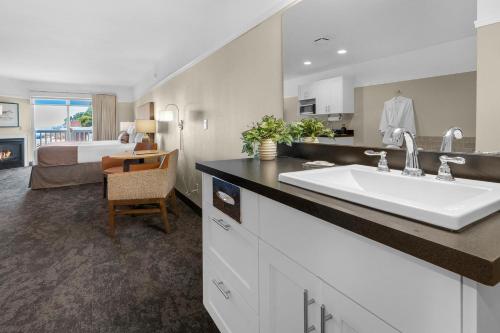 a bathroom with a sink and a bedroom with a bed at Looking Glass Inn in Lincoln City