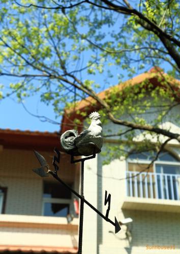 a bird perched on a pole in front of a house at Xiangyang Tianyuan in Sanyi