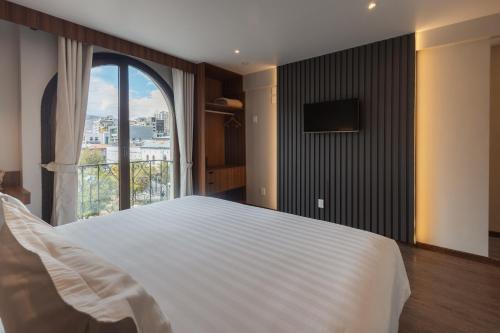 ein Schlafzimmer mit einem großen weißen Bett und einem Fenster in der Unterkunft DREAM By Stannum Hotel in La Paz