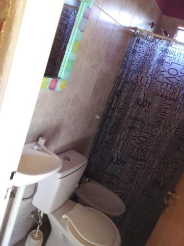 a bathroom with a toilet and a shower curtain at Xaraba in Villa Parque Siquiman