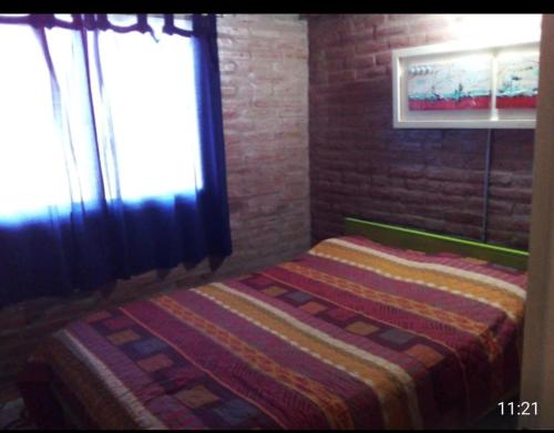 a bedroom with a bed and a window with a blanket at Xaraba in Villa Parque Siquiman