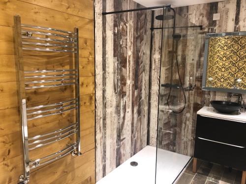 a shower in a bathroom with a wooden wall at Roundstone View in Bewdley