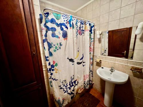 a bathroom with a shower curtain and a sink at Lupita's House in Punta Mujeres