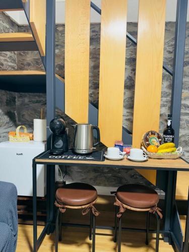 a table with two stools with a pot on it at Cozy House in Funchal