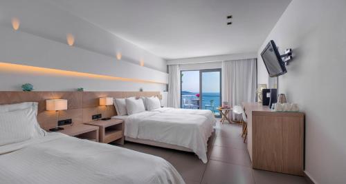 a hotel room with two beds and a television at Adrina Resort & Spa in Panormos Skopelos