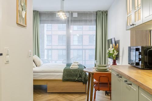 a small bedroom with a bed and a window at LILY APART - Foodhall & Rooftop Terrace in Gdańsk
