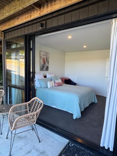 a bedroom with a large bed and a glass door at Moana BnB, Picton in Picton