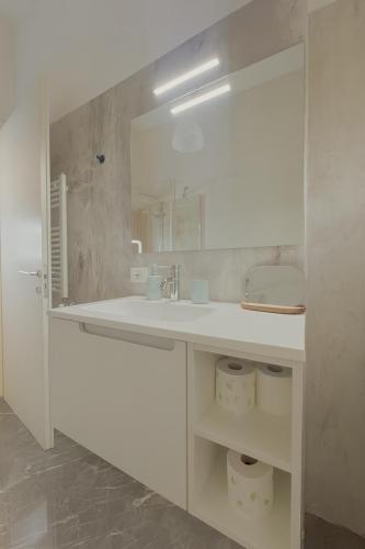 a white bathroom with a sink and a mirror at La Casa del Borgo in Rieti