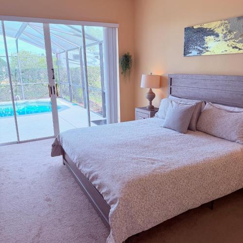 a bedroom with a bed and a sliding glass door at Luxury 5 Bedroom Villa with Secluded Pool/Spa in Glenbrook community near Orlando in Orlando