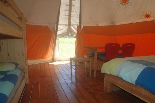 a bedroom with two beds and a table and chairs at camping roussel in Saint-Paul-dʼEspis