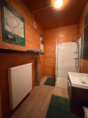 a bathroom with a shower and a white refrigerator at Fiets Kot in Keerselaar