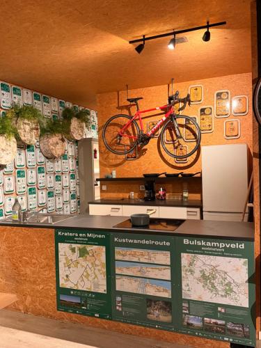 a red bike hanging on a wall in a store at Fiets Kot in Keerselaar