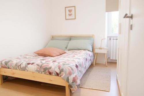 a small bedroom with a bed with a wooden frame at La Casa del Borgo in Rieti