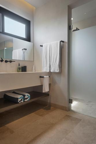 a bathroom with a sink and a mirror at Luxury 3BR Apartmen Tankah Beach plus Rooftop in Tulum