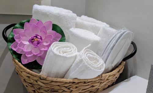 a basket filled with towels and a purple flower at B&B Civico 11 in Veglie