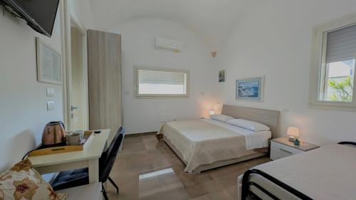 a hotel room with two beds and a desk and a bed at B&B Civico 11 in Veglie