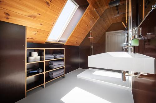 a bathroom with a white sink and a skylight at Feriengut Welzin in Welzin