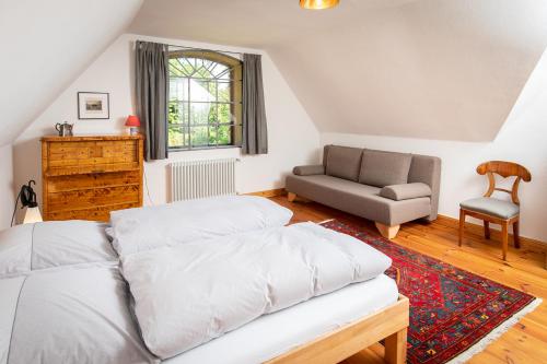 a bedroom with a bed and a couch and a chair at Feriengut Welzin in Welzin