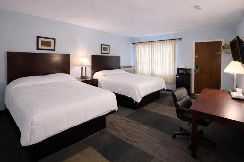 a hotel room with two beds and a desk at St Croix Suites - St Croix Falls in Saint Croix Falls