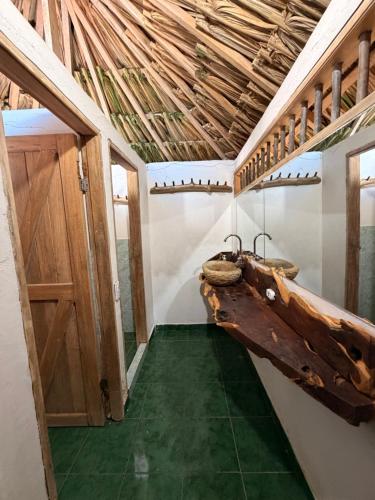 a bathroom with two sinks in a room with a wooden ceiling at Cabaña con Deck Frente al Mar para 8 personas in Moñitos