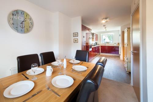 a dining room with a wooden table and chairs at BEACHES - South Sands beach house in Torquay