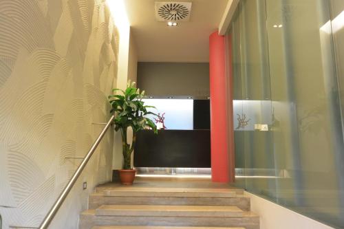 a hallway with red columns and a potted plant at Hotel Corallo in Milan