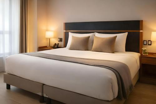 ein Schlafzimmer mit einem großen weißen Bett und Kissen in der Unterkunft Hotel Vía Norte Inn - Nuevo - Estacionamiento gratis - Ubicación estratégica in Tuxtla Gutiérrez