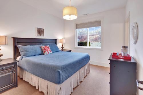 a bedroom with a blue bed and a window at Sunny Getaway at Veranda Beach in Oroville