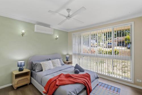a bedroom with a bed and a large window at Lemon Tree Getaway Inn in Lemon Tree Passage