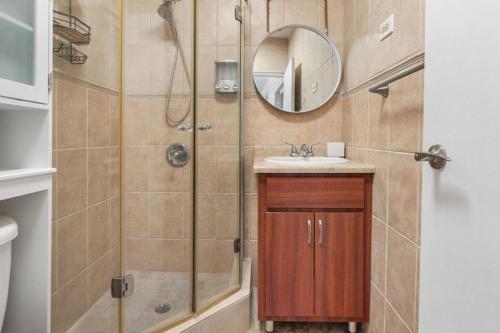 a bathroom with a shower with a sink and a mirror at Ocean Vibes near Rincón Beachfront Access Condo in Matias