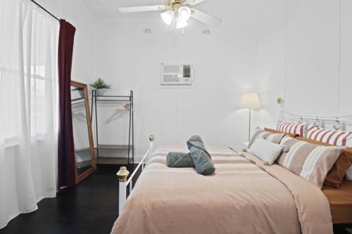 a bedroom with a bed and a ceiling fan at Mildas Cottage Hunter Valley in Cessnock