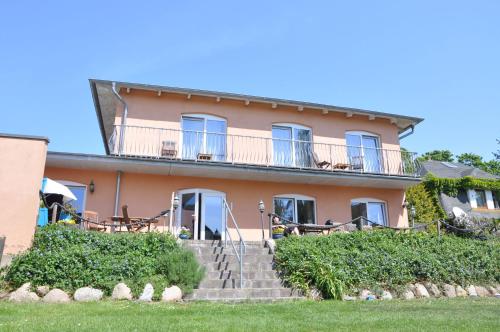 a large pink house with stairs in front of it at Pension Waldeck in Göhren