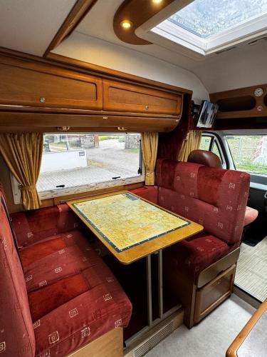 a table in the back of a van with red chairs at Rover Rentals in Inverness