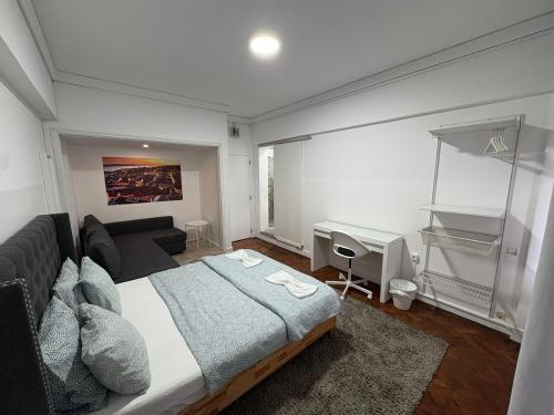 a bedroom with a large bed and a desk at Hotel Campo Pequeno in Lisbon