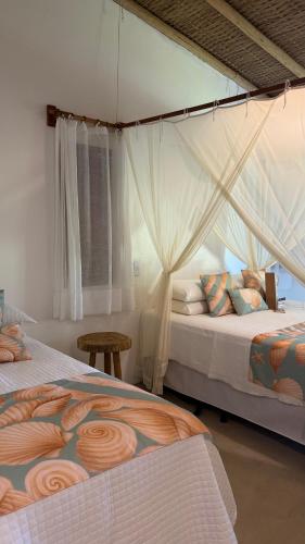 a bedroom with two beds and a window at Vila Sereia Caraiva in Caraíva