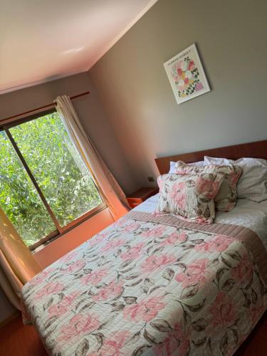 a bedroom with a bed and a large window at Radal Riverside Lodge in El Torreón