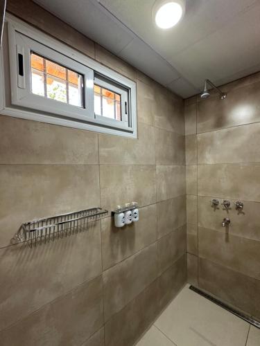 a bathroom with a shower and a window at Etel Departamentos in San Rafael