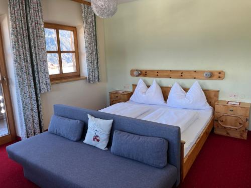 a bedroom with a large bed and a couch at Pension Patz in Schladming