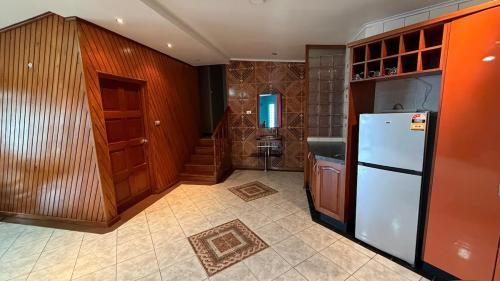 a kitchen with a white refrigerator and wooden cabinets at Blissfull Corner at Centerpoint Unit 1 in Suva