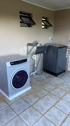 a washing machine and a sink in a room at Blissfull Corner at Centerpoint Unit 1 in Suva