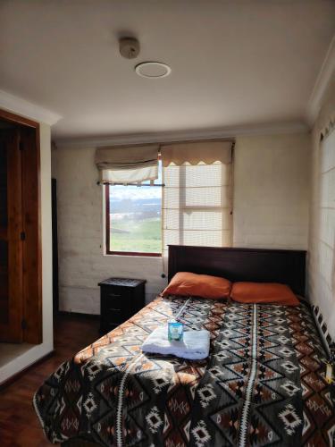 a bedroom with a bed with a tray on it at Hostal Casa Cotopaxi in Latacunga