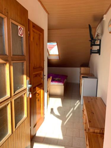 an attic room with a door and a bed at Rybářská bašta-Vikletice in Kwon