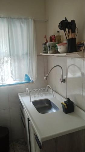 a kitchen counter with a sink and a window at Casas oliveira in Paraty