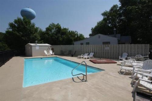 a swimming pool in a yard with chairs and a fence at The Retreats at Stone Fountain in Arnolds Park