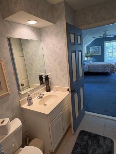 a bathroom with a sink and a toilet and a bedroom at Spacious Home Bethany Beach in Frankford