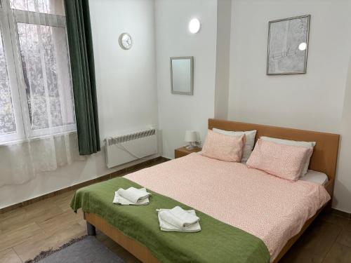 a bedroom with a bed with two towels on it at Apartments Ozren in Soko Banja