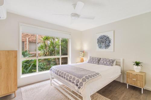 a bedroom with a bed and a large window at Tahnee Court Unit 3 in Gold Coast